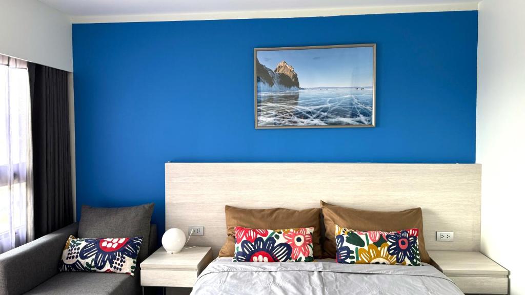 Un dormitorio con una pared azul y una cama con almohadas en HuaHin DusitD2 Residences, apartments near beach, en Hua Hin