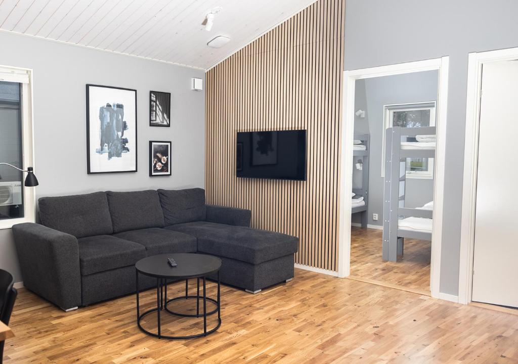 een woonkamer met een bank en een tafel bij Kapelludden Camping & Stugor in Borgholm