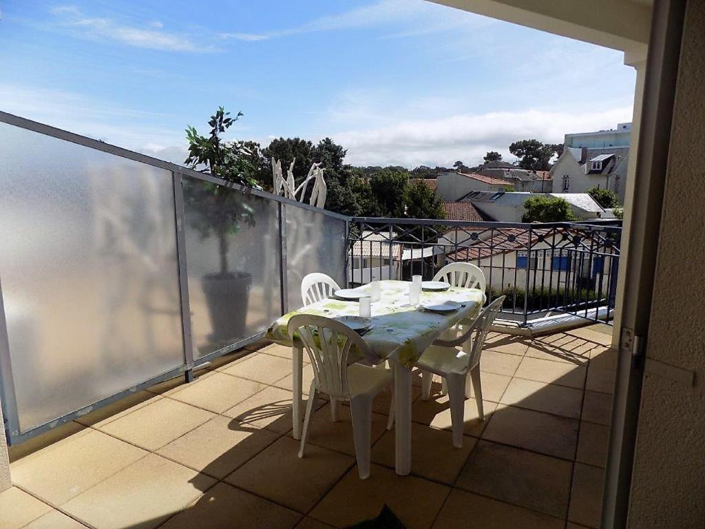 una mesa y sillas en un balcón con vistas en Vaux sur Mer - Quartier PONTAILLAC - APPARTEMENT - PISCINE COLLECTIVE, en Vaux-sur-Mer