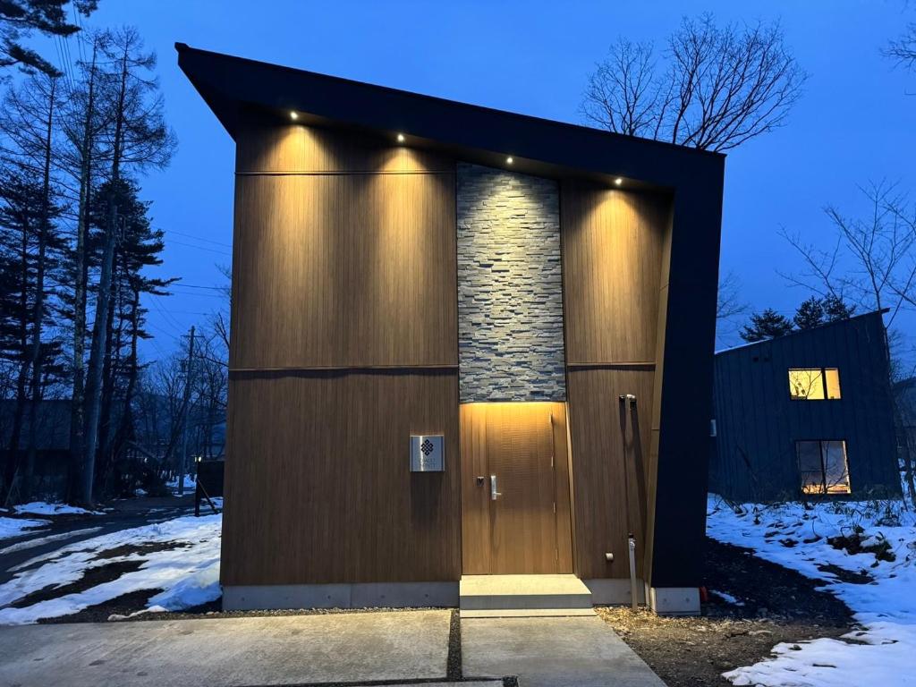 ein kleines Gebäude mit einer Tür im Schnee in der Unterkunft Chalet Infinity by The Hakuba Collection in Hakuba