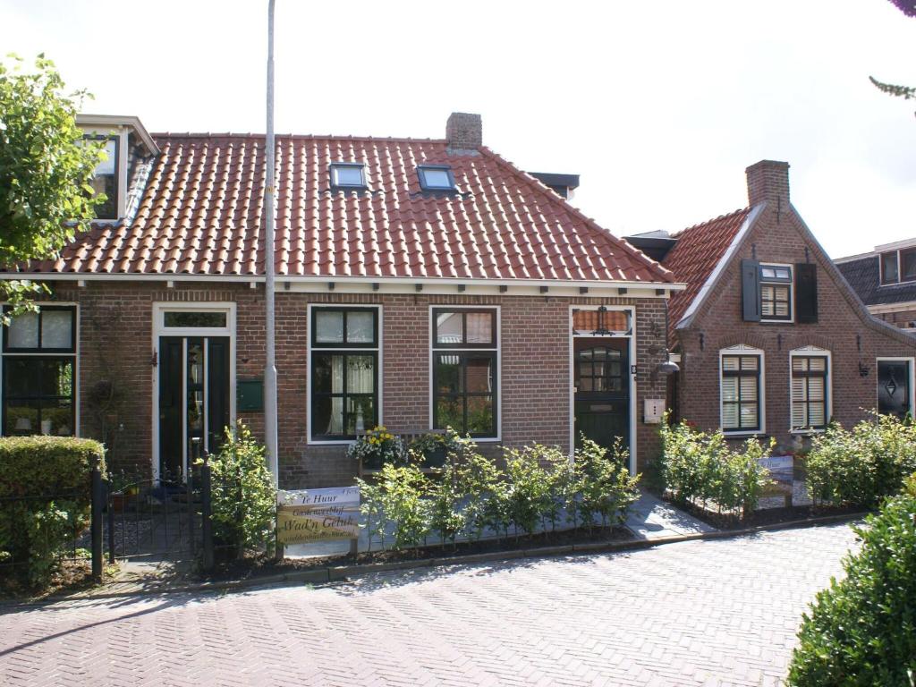 una casa de ladrillo con techo de baldosas rojas en Fantastic luxury vacation home and next to the Wadden Sea, en Paesens