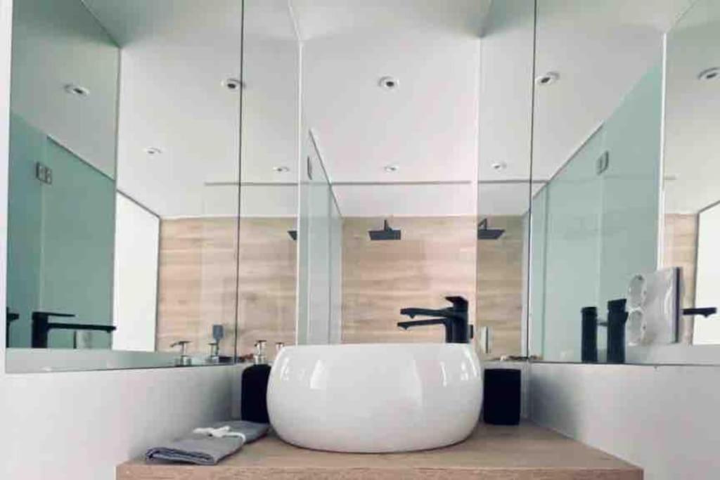 ein Badezimmer mit einem Waschbecken und einem großen Spiegel in der Unterkunft Unique NYC style Loft in the heart of Madrid in Madrid