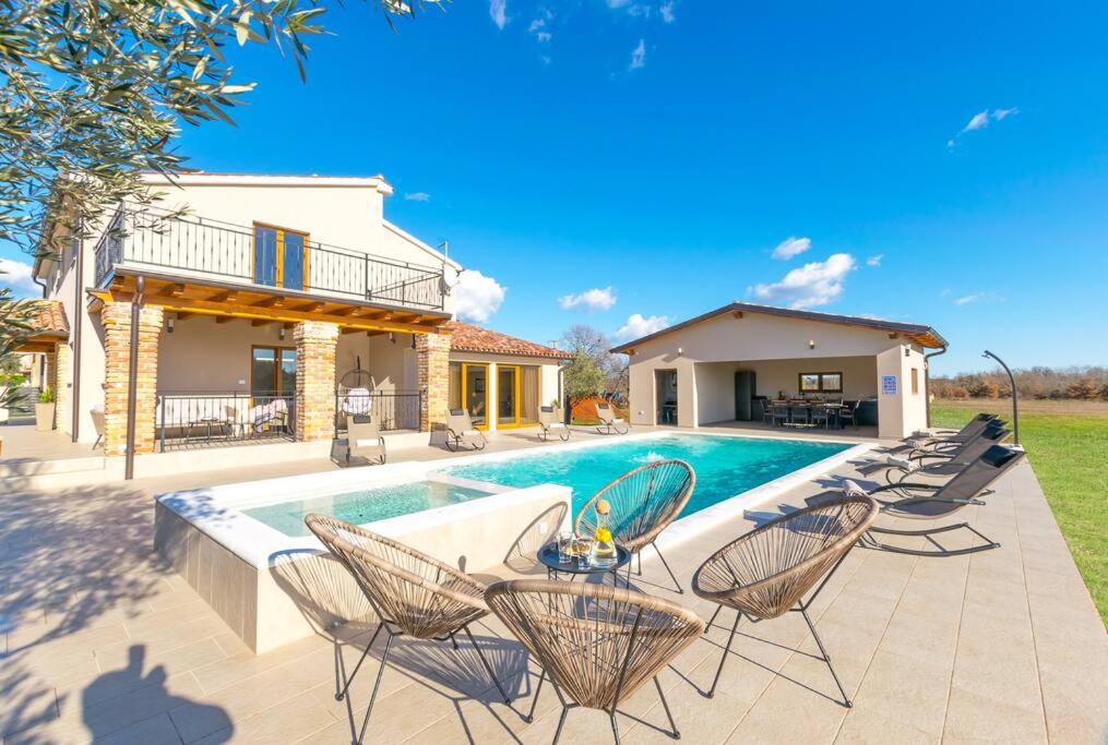 un patio avec des chaises et une piscine dans l'établissement Villa Rosa by IstriaLux, à Loborika