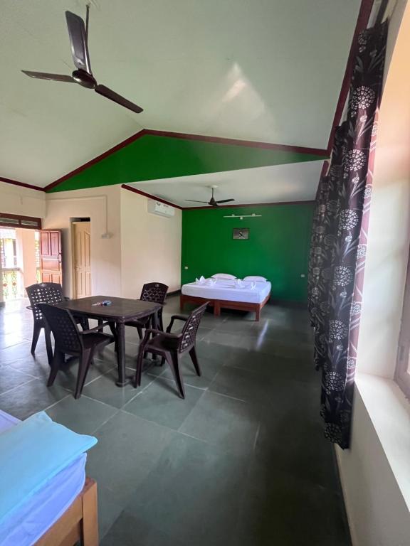una stanza con tavolo, sedie e parete verde di Green valley jungle resort 