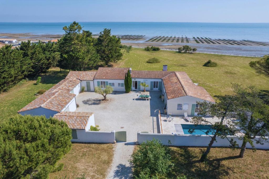 an aerial view of a house with the ocean behind it at Le Clos du Pertuis in La Flotte
