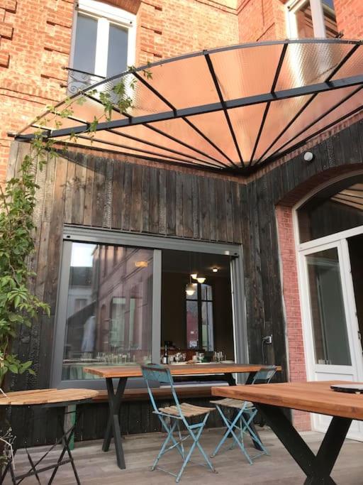 d'une terrasse avec des tables et des chaises devant une fenêtre. dans l'établissement Maison familiale éco rénovée, à Ault