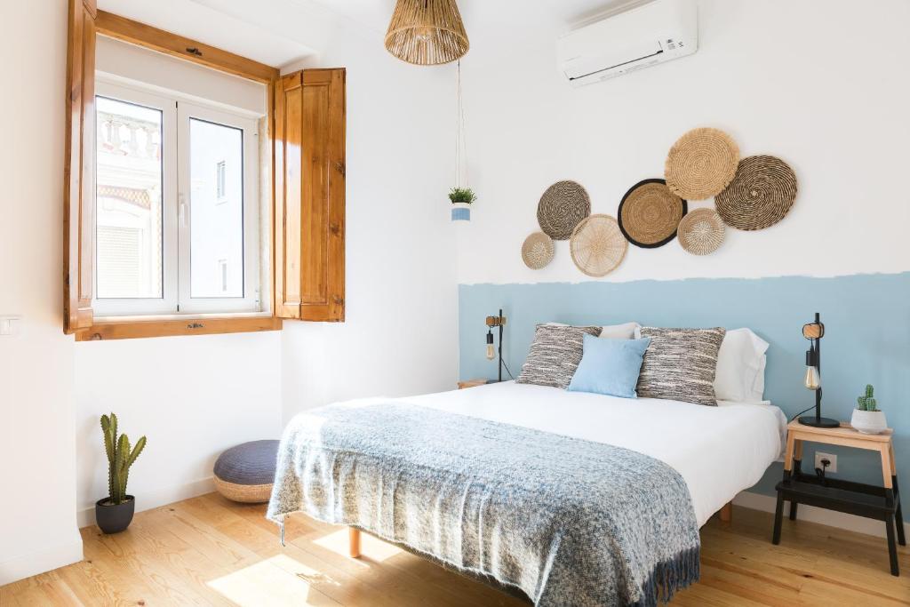 a white bedroom with a bed and a window at Feel Home in this Stunning Renovated Nest in Graça in Lisbon