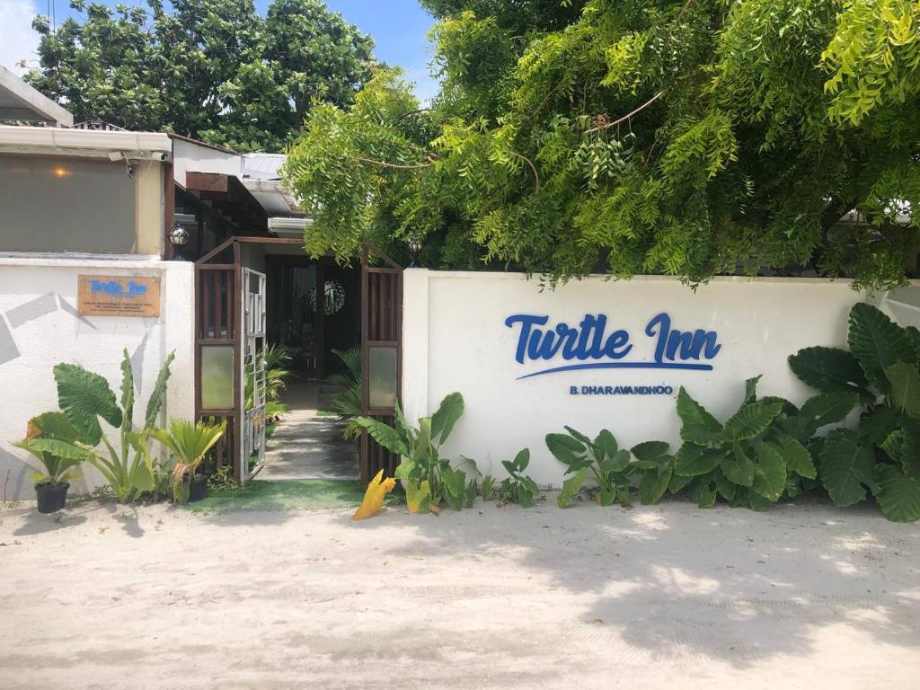 達拉凡度的住宿－Turtle Inn Dharavandhoo，一座有标牌的建筑,上面写着海龟旅馆
