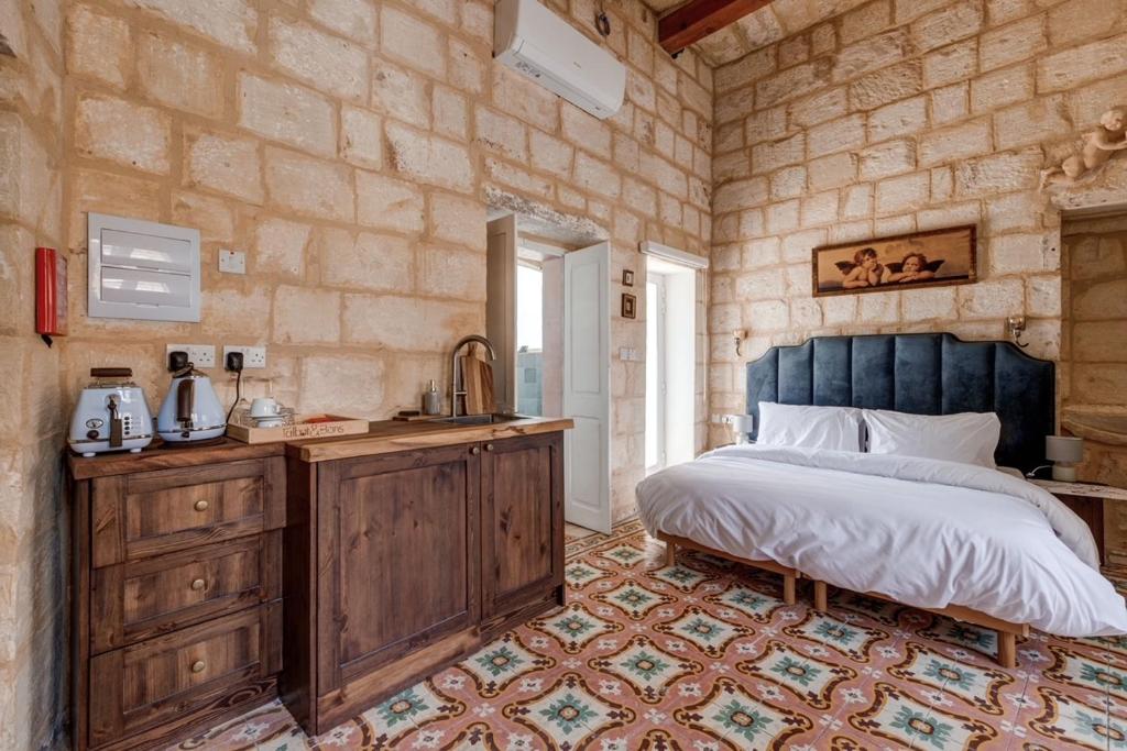 1 dormitorio con 1 cama y lavamanos. en Talbot House by Talbot & Bons, en Luqa