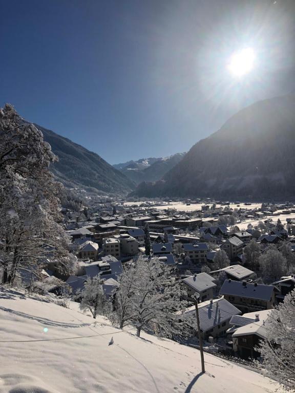 a village covered in snow with the sun in the background at Appartement Haus Honold in Schruns