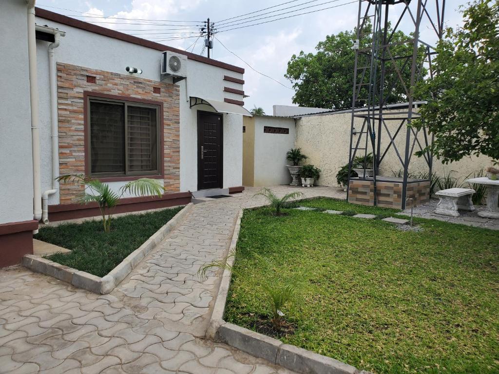 a backyard of a house with a grass yard at Lovely 1 bedroom self catering apartment in Lusaka