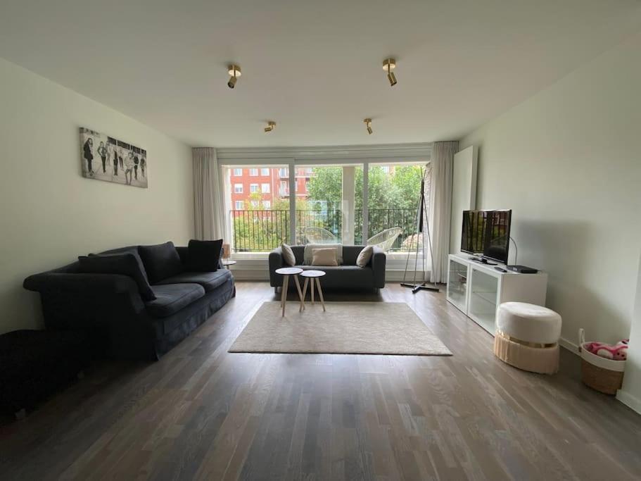 uma sala de estar com um sofá e uma televisão em Recent en lichtrijk duplex-appartement te Wenduine em Wenduine
