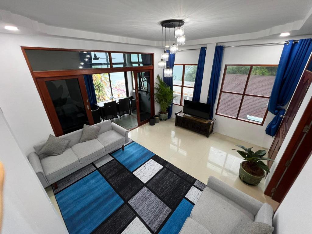 Amara Beach Resort Koh Phangan في هاد ياو: غرفة معيشة مع أريكة وتلفزيون