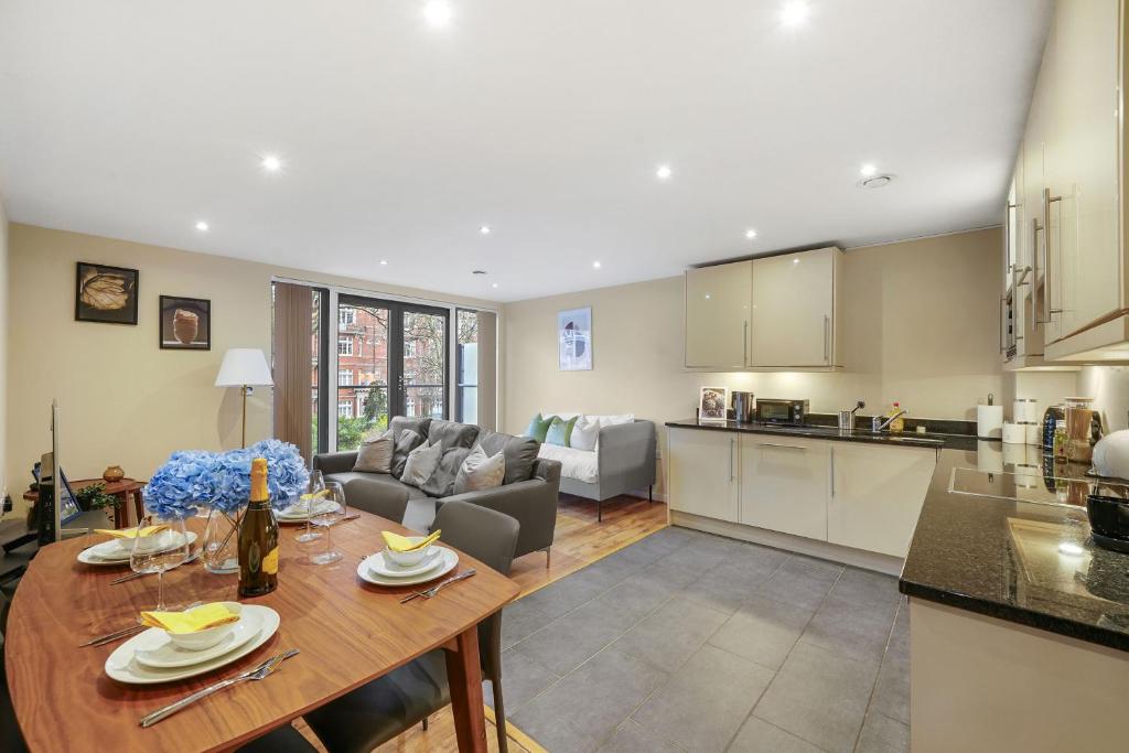 a kitchen and living room with a wooden table in a kitchen at LiveStay-Stunning 2 Bed 2 Bath Apartment in Maida Vale in London