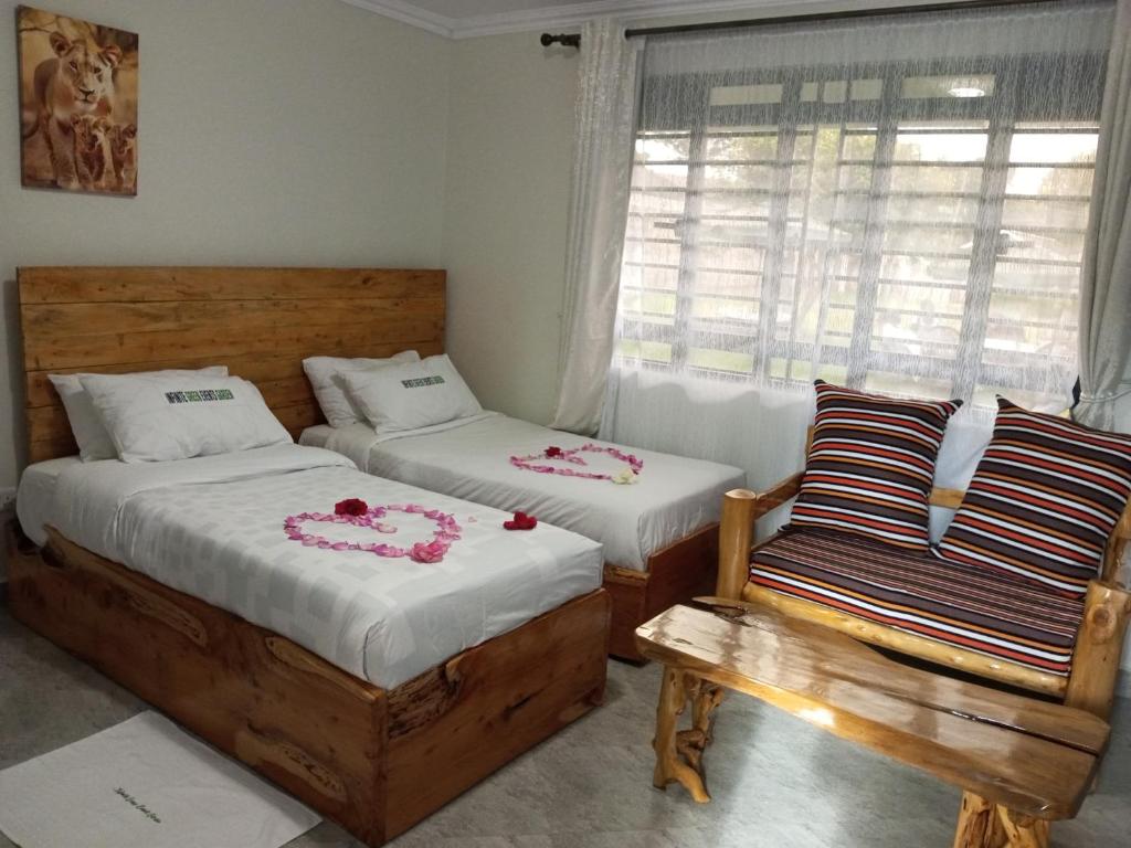 a bedroom with two beds and a chair and a window at INFINITE GREEN EVENTS GARDEN AND ACCOMMODATION in Dowsonville