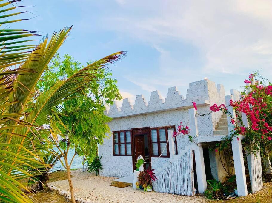 una casa blanca con flores delante en Makunduchi Waterfront paradise, en Tongoni