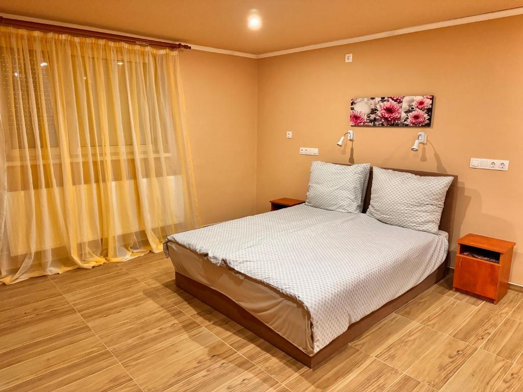 a bedroom with a bed and a large window at Krisz Apartman in Gyula