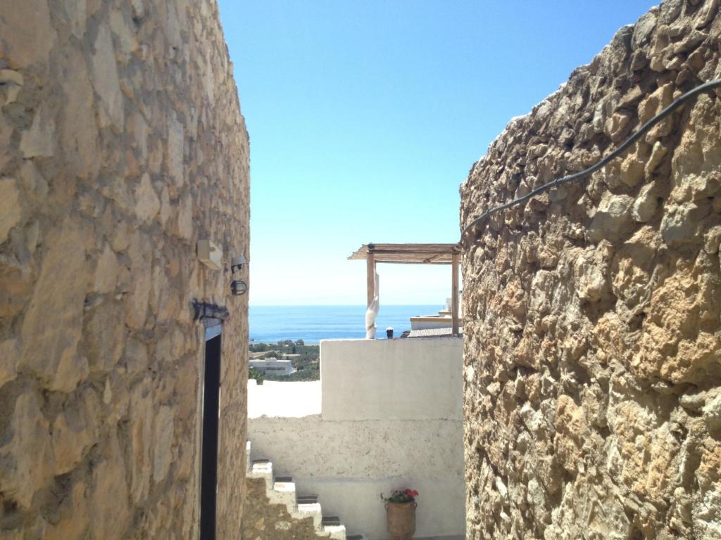 a view of the ocean from a stone wall at Koutsounari Traditional Cottages in Koutsounari