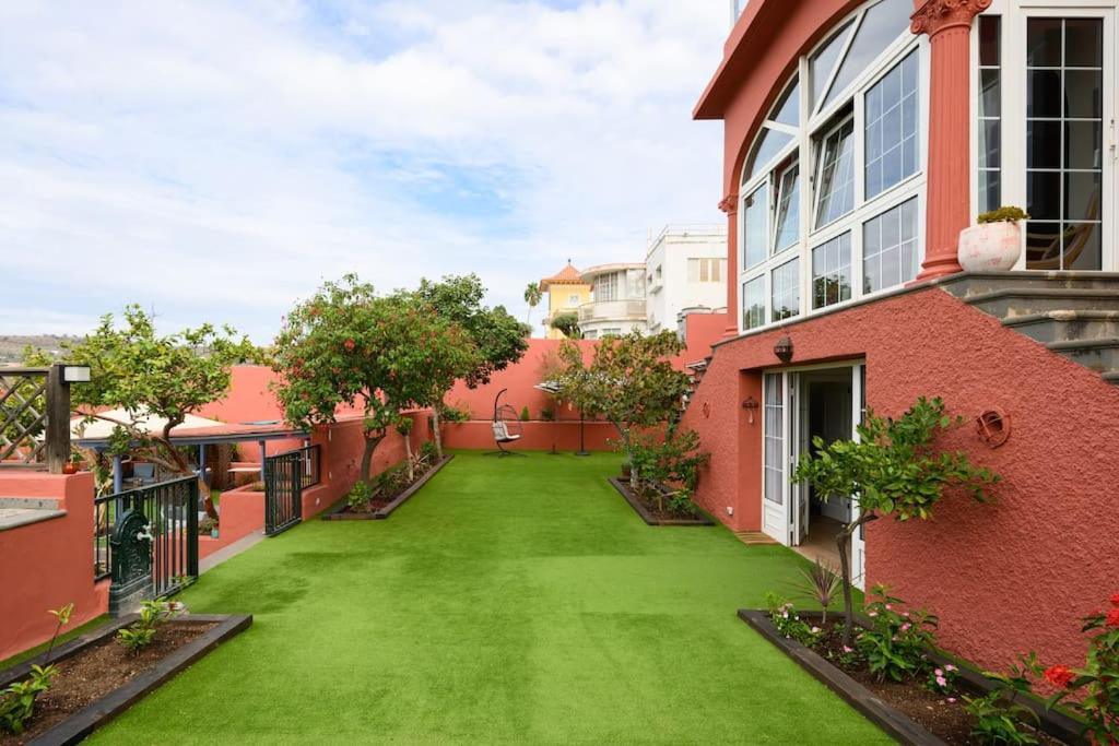 um quintal de uma casa com um relvado verde em Pool Suite Carmen em Las Palmas de Gran Canaria