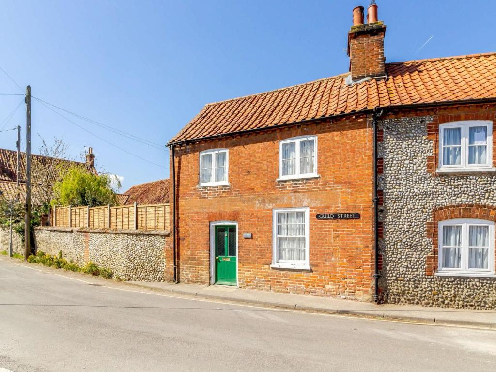 a brick building with a green door on a street at 2 Bed in Little Walsingham KT093 in Little Walsingham