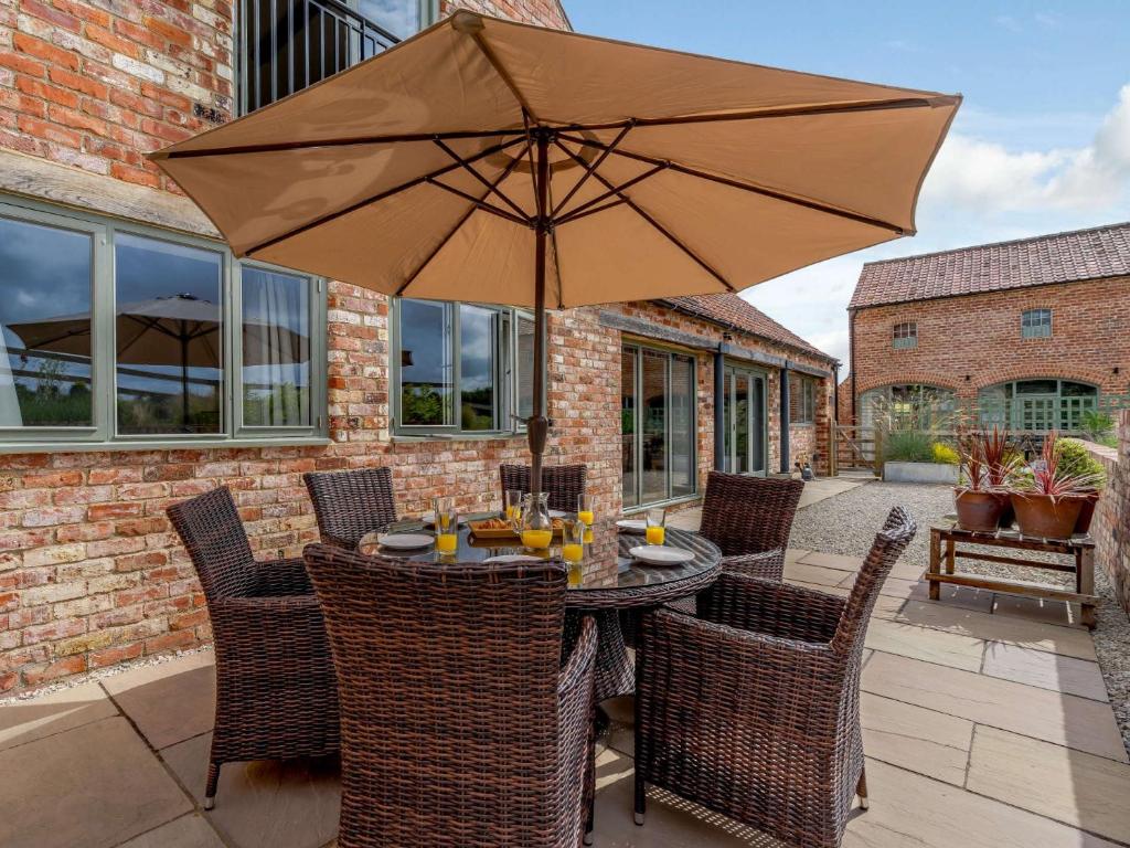 a table with an umbrella on a patio at 3 Bed in Malton 75899 in Amotherby