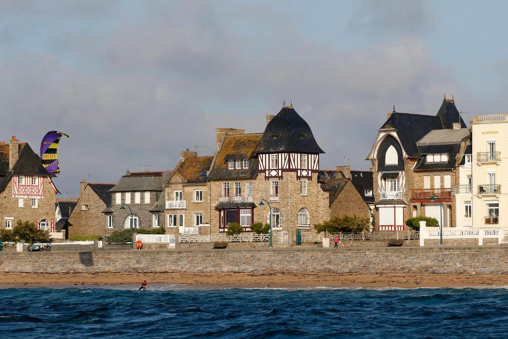 un gruppo di edifici su una spiaggia con acqua di Villa Ellerslie a Saint Malo