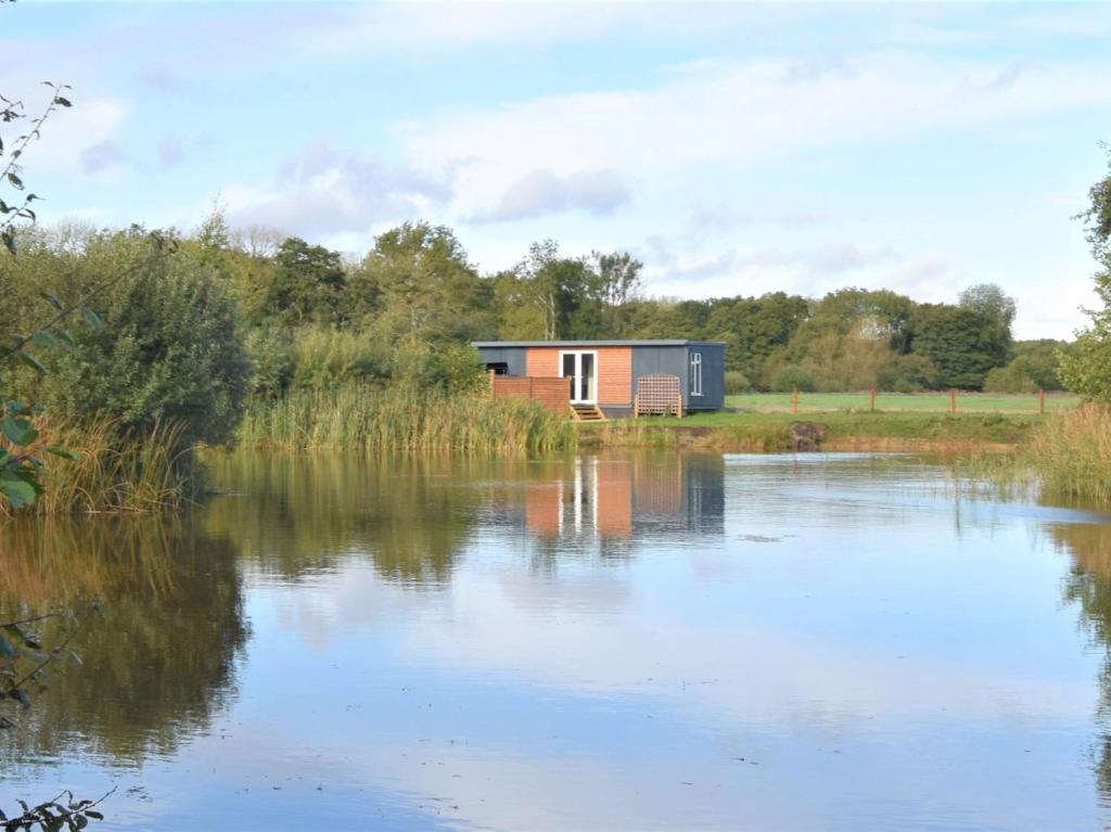 uma pequena casa ao lado de um lago em 1 Bed in Thetford 76493 em East Harling