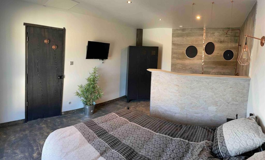 a bedroom with a large bed and a tub at Les Gîtes de la Warenne - Gîte 2 in Saint-Étienne-au-Mont