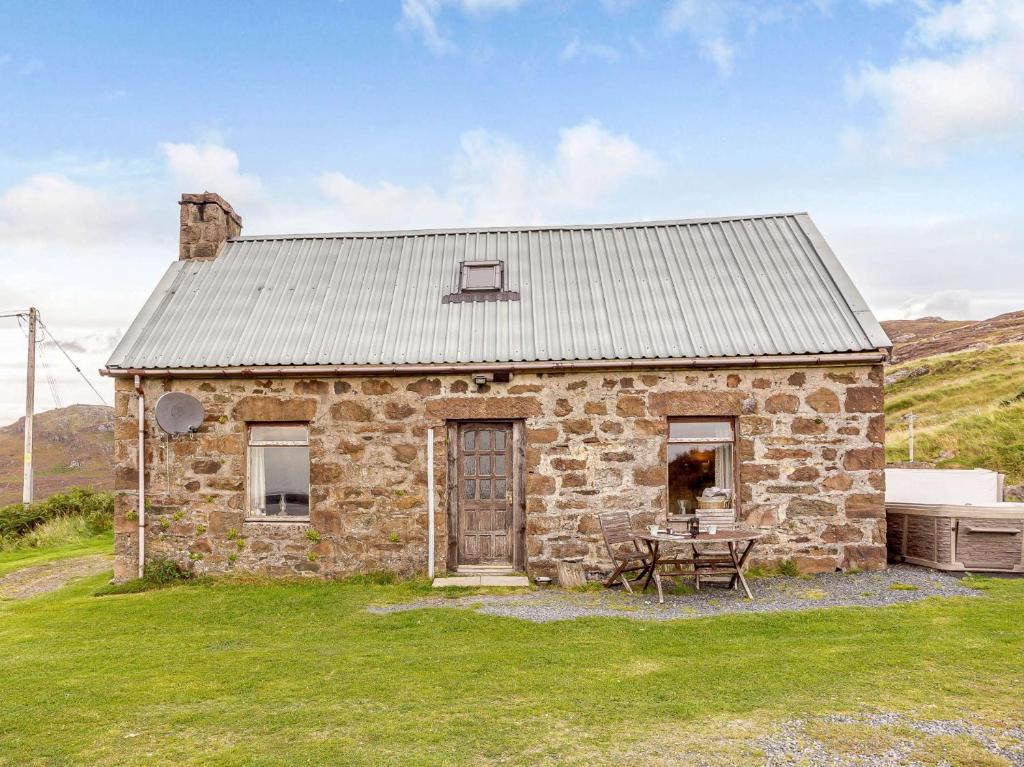 an old stone house with a table in front of it at 1 bed property in Strath CA044 in Gairloch