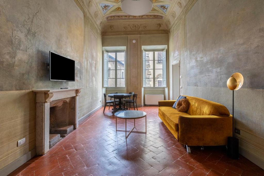 numa I Felice Rooms & Apartments في فلورنسا: غرفة معيشة مع أريكة ومدفأة