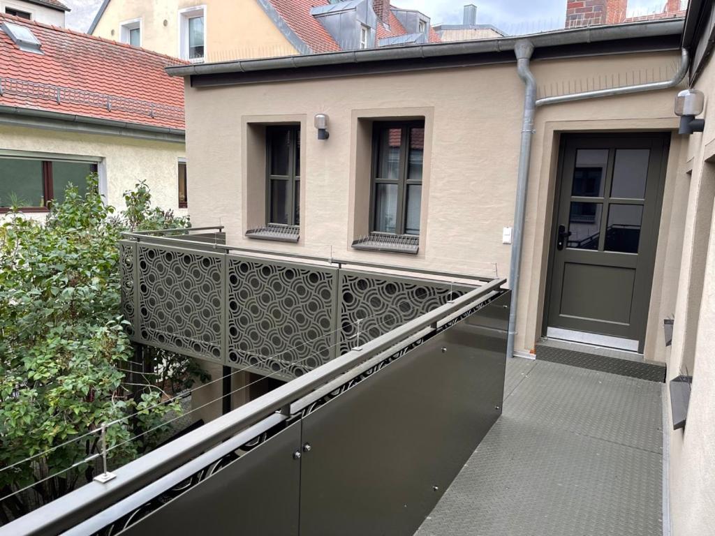 einen Balkon mit einem Zaun neben einem Gebäude in der Unterkunft Pebbles Suiten by RiNG in Regensburg