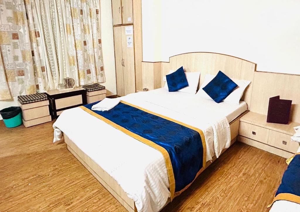 a bedroom with two beds with blue pillows at Dhe Kyi Khang by Magwave Hotels-100 Mts from MG Marg in Gangtok