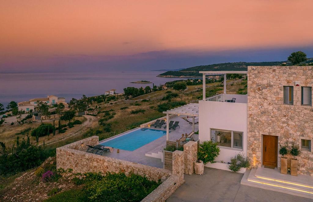 een villa met een zwembad bij zonsondergang bij Villa Avgi in Agios Nikolaos