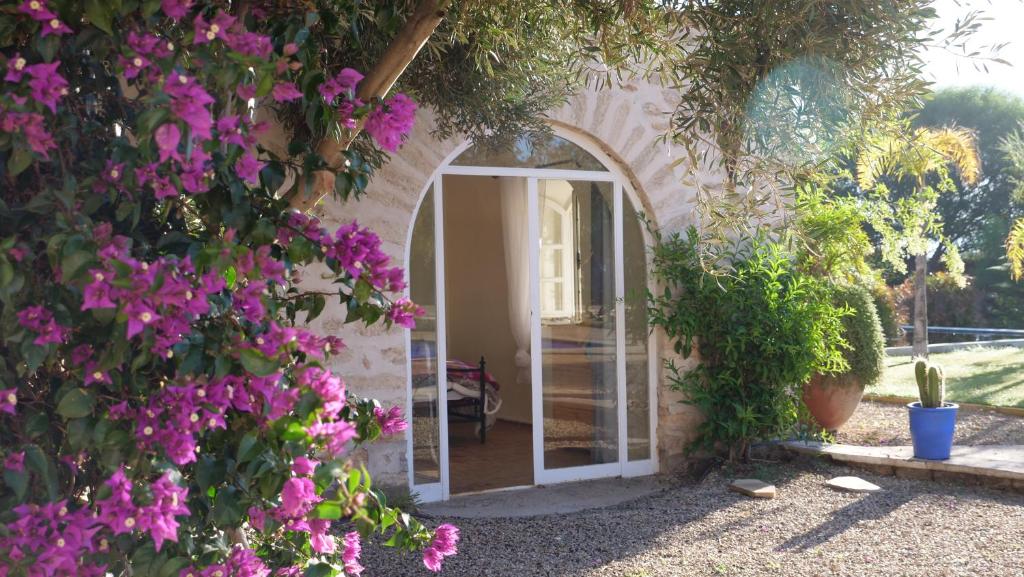 una puerta arqueada a una casa con flores púrpuras en Dar Luce, en Essaouira