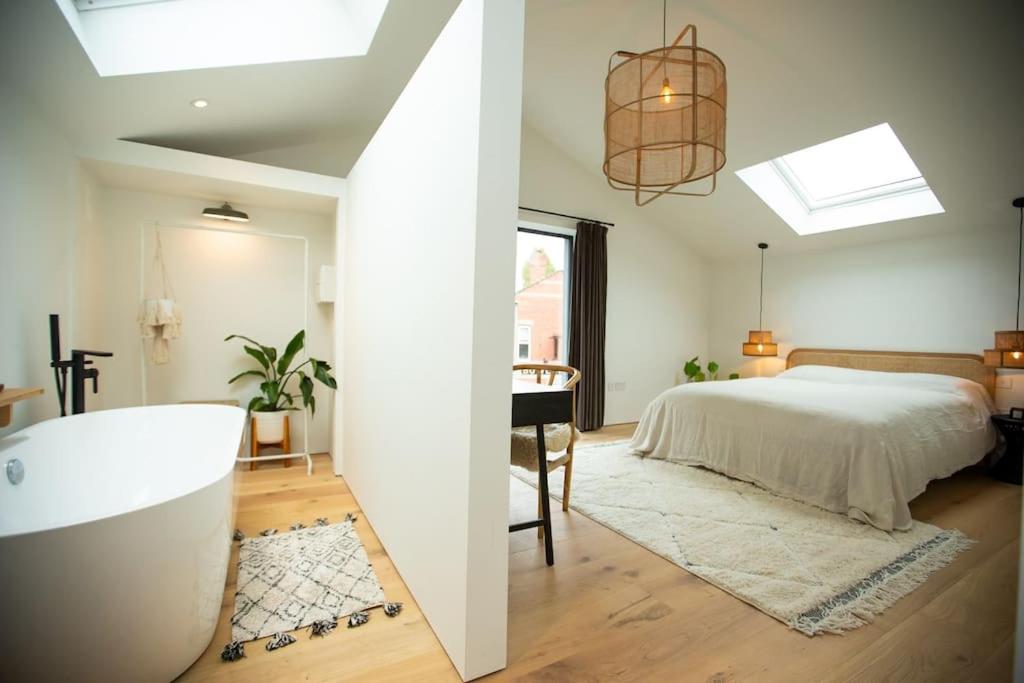 a bedroom with a bed and a tub in a room at Chorlton Stylish Studio & Roof Terrace Apartments in Manchester