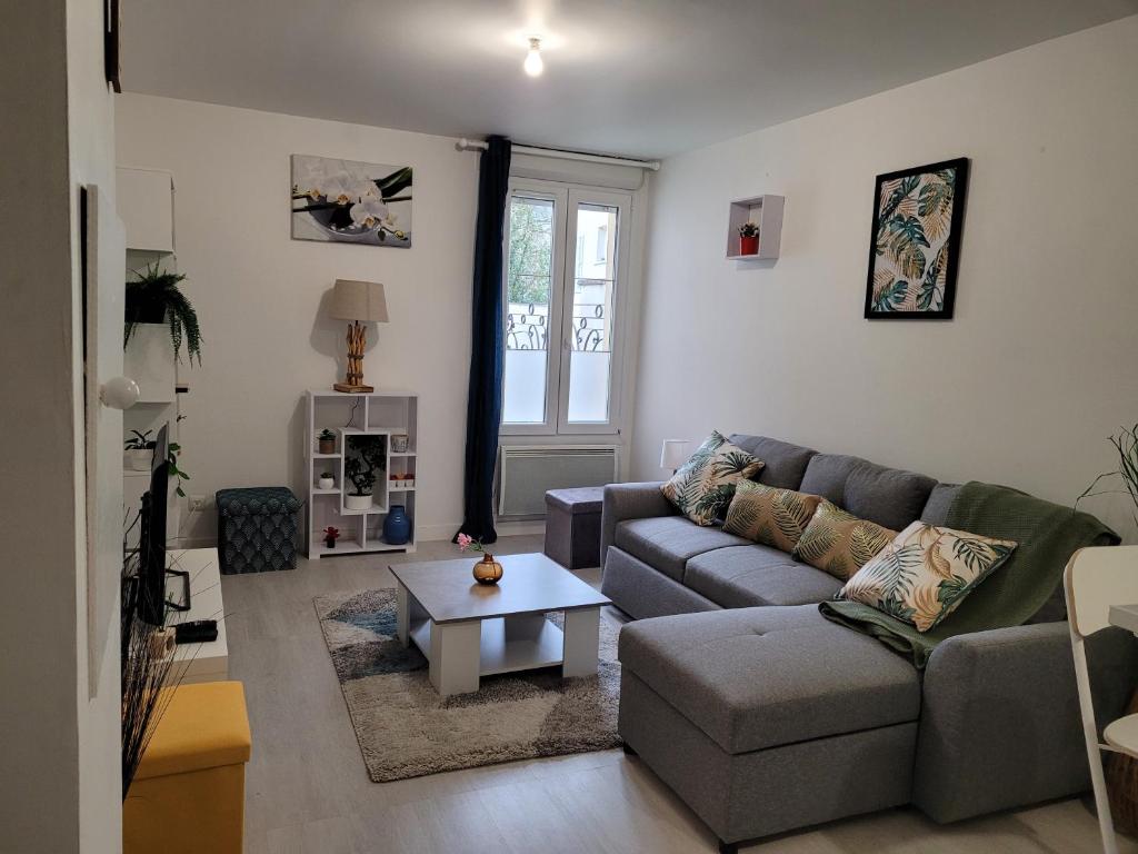 uma sala de estar com um sofá e uma mesa de centro em Cocooning House 204 Suite Green- Superb studio Aéroport PARIS Roissy CDG, Parc ASTERIX, Château de CHANTILLY, STADE DE FRANCE em Survilliers
