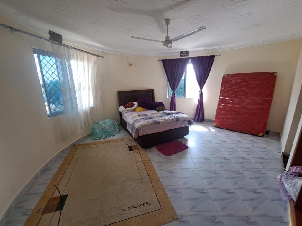ein Schlafzimmer mit einem Bett und einem Karton aus Pappe auf der Etage in der Unterkunft Diamond Sands Villa in Ukunda
