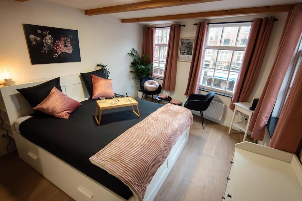 Un dormitorio con una cama grande y una mesa. en Best Neighbourhood Apartment en Ámsterdam