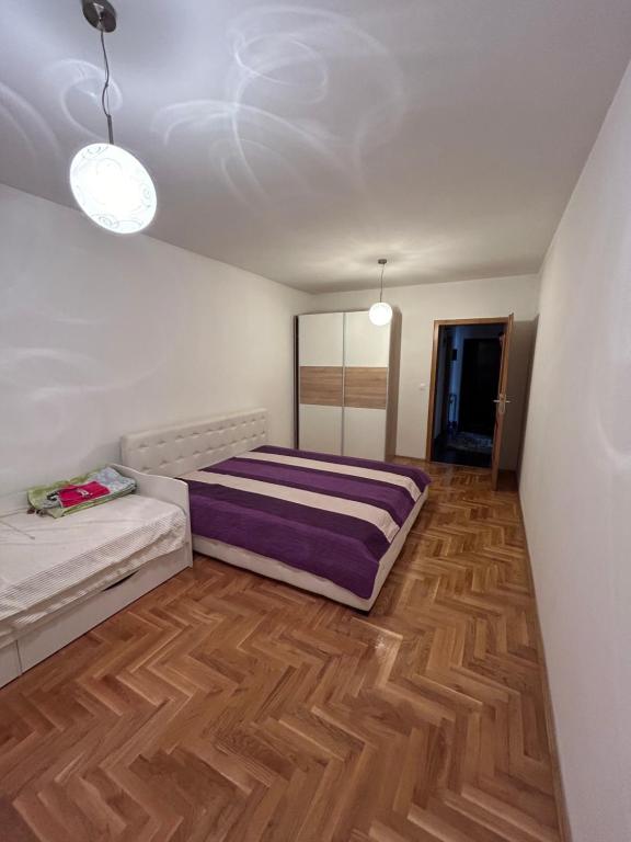 um quarto com uma cama e piso em madeira em Apartman SARA em Sarajevo