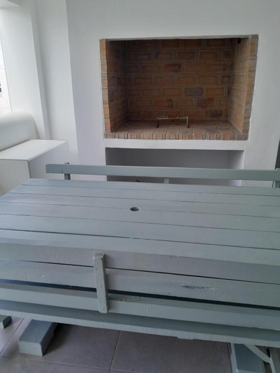 a bench in front of a brick fireplace at Apartment West in Velddrif