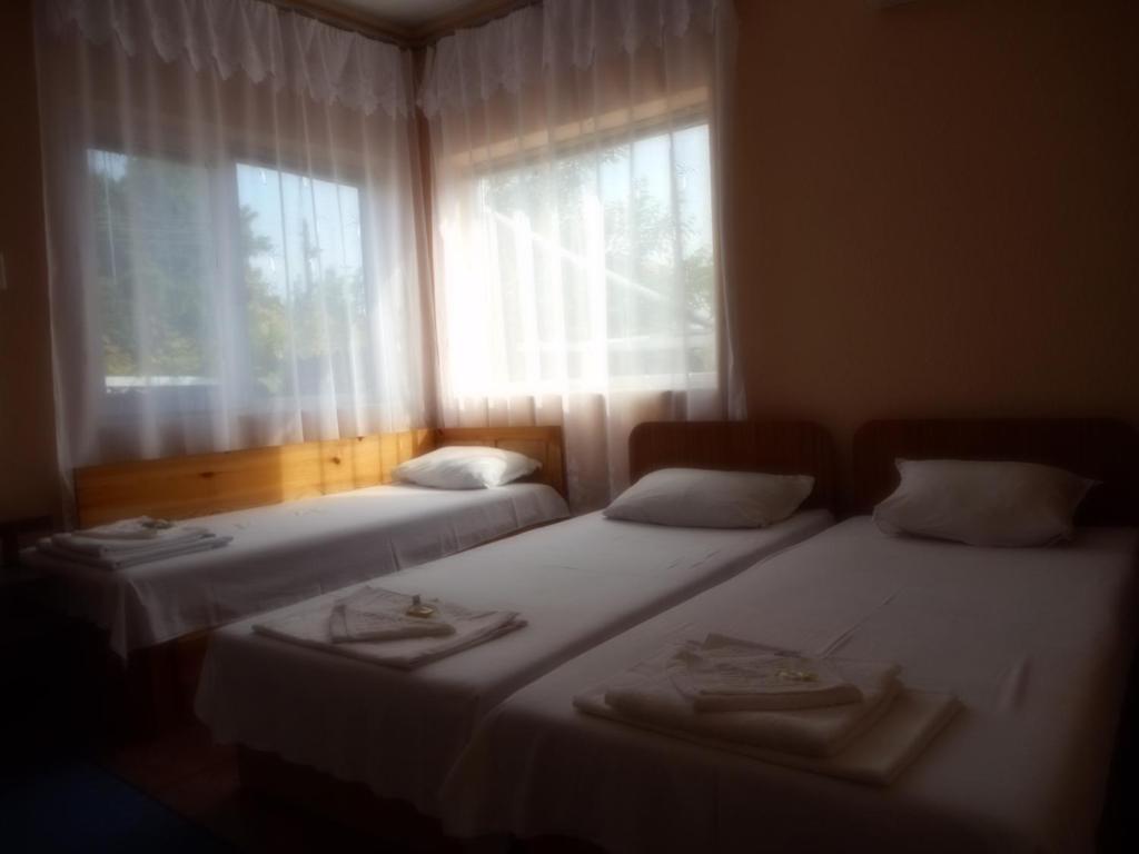 two beds in a room with a window at Guest House Borisov in Shabla