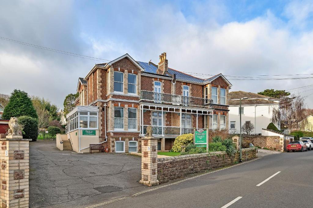 a large brick house on a street at Finest Retreats - Atherfield Apartments No 6 - Tree Tops in Paignton