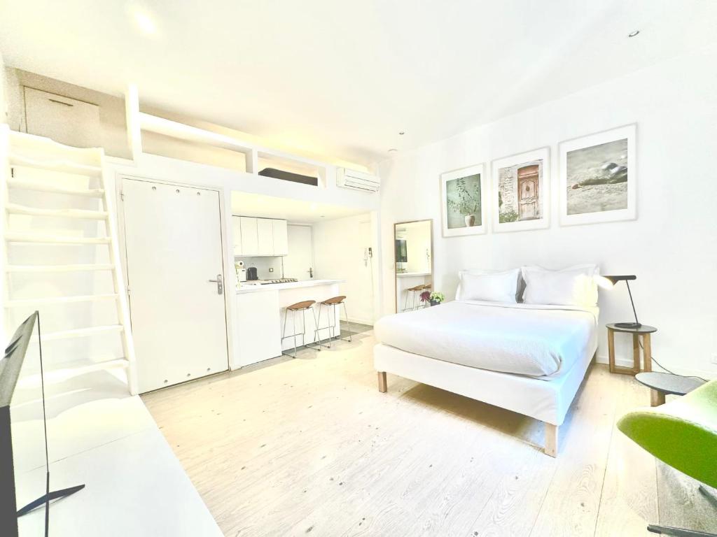 a white bedroom with a bed and a staircase at Èrsextius ABB Aix-en-Provence in Aix-en-Provence