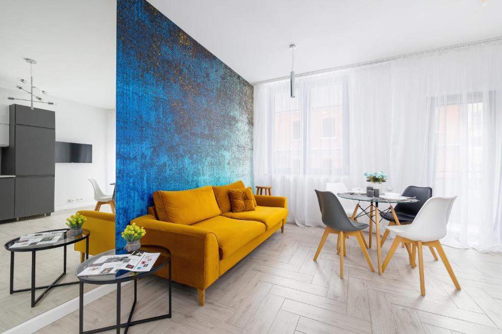un soggiorno con divano giallo e tavolo di Złota Apartment with Balcony & Parking Near Zoo Katowice by Renters a Katowice