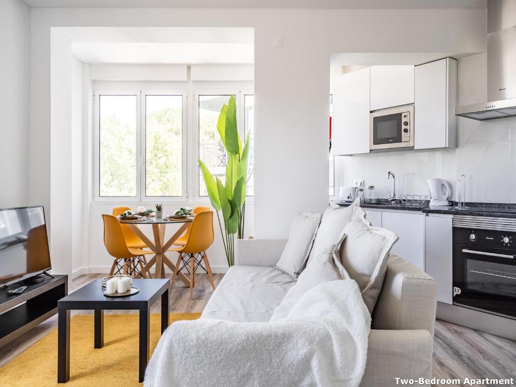 a white living room with a couch and a table at Akicity Campolide Sun in Lisbon