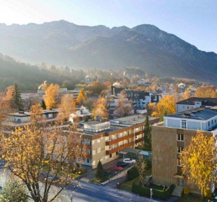 a city with buildings and trees with mountains in the background at Appartement Sternblick in Bad Reichenhall