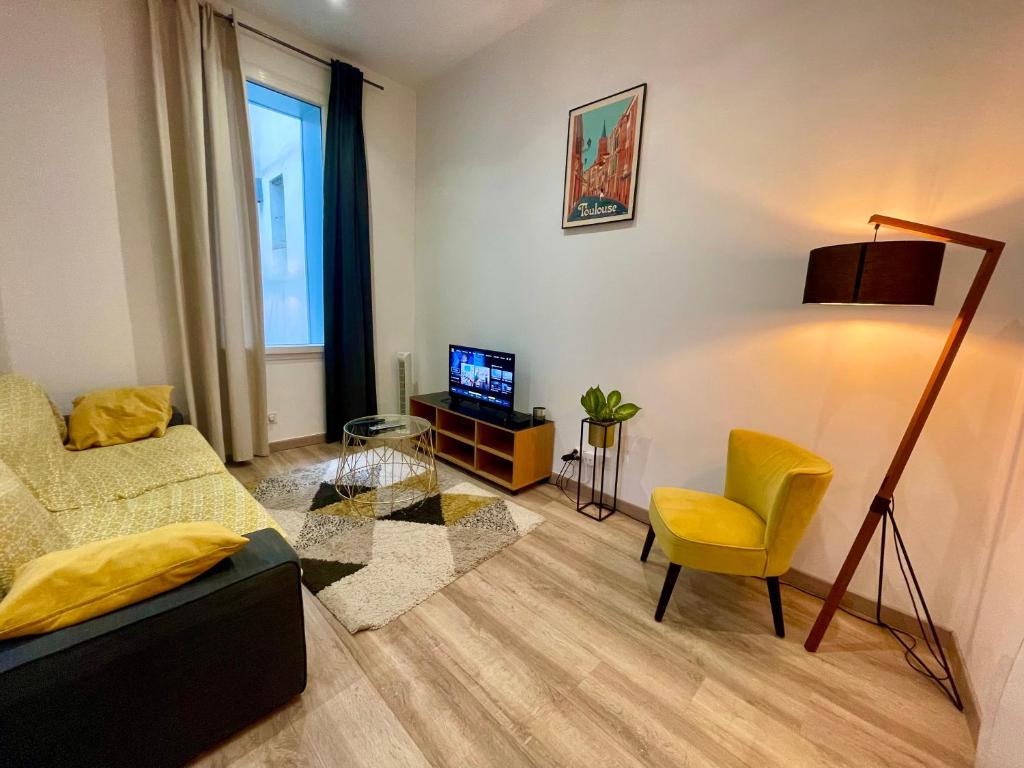 - un salon avec un canapé, une chaise et une télévision dans l'établissement Capitole, Grand T1 bis, lumineux, neuf., à Toulouse
