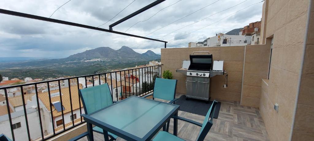 einen Balkon mit einem Tisch, Stühlen und einem Herd in der Unterkunft Casa Rural Lunares y Salinera in Albanchez de Úbeda