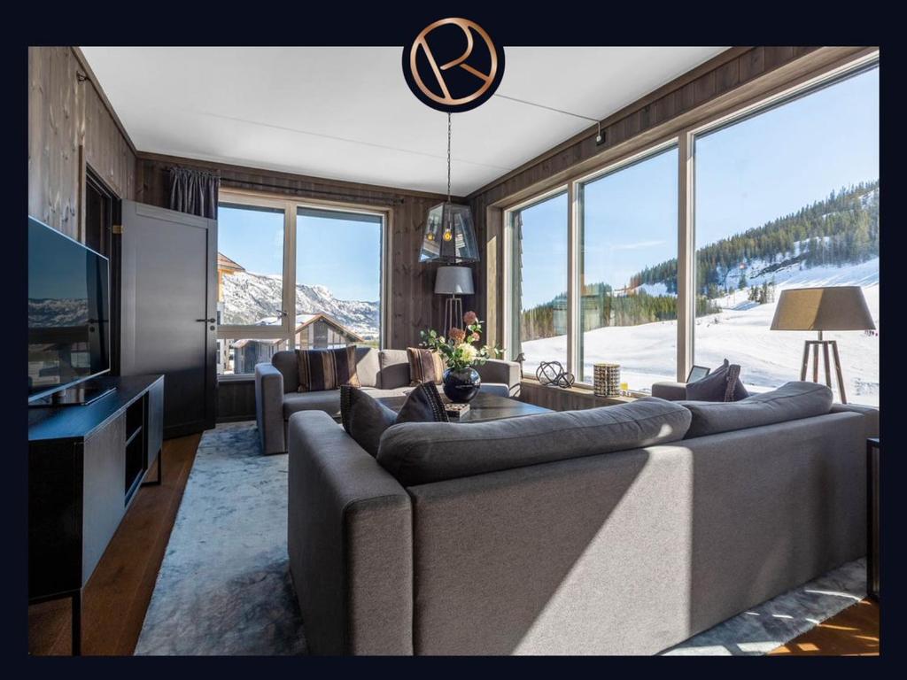 a living room with a large couch and a tv at Fyri Resort nr 14 in Hemsedal
