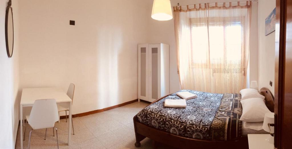 ローマにあるSan Giovanni Apartmentのベッドルーム1室(ベッド1台、テーブル、デスク付)
